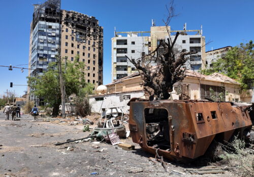 A destroyed military vehicle and bombed buildings in Khartoum.