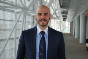 Headshot of Vito Dellerba standing in office hallway.